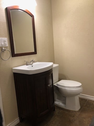 bathroom with tile patterned flooring, vanity, and toilet