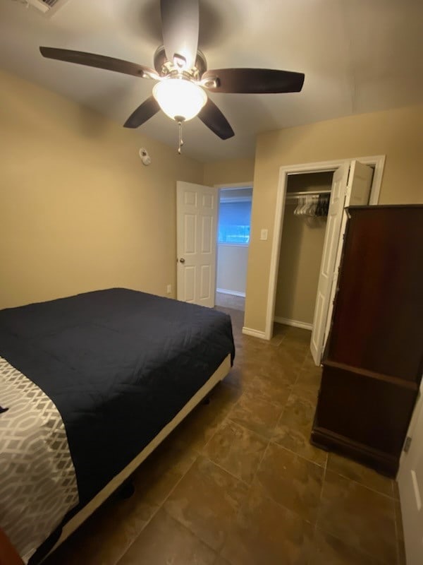 bedroom featuring dark tile patterned flooring and ceiling fan