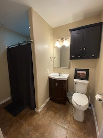 bathroom with tile patterned flooring, vanity, and toilet