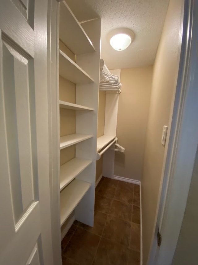 walk in closet featuring dark tile patterned flooring