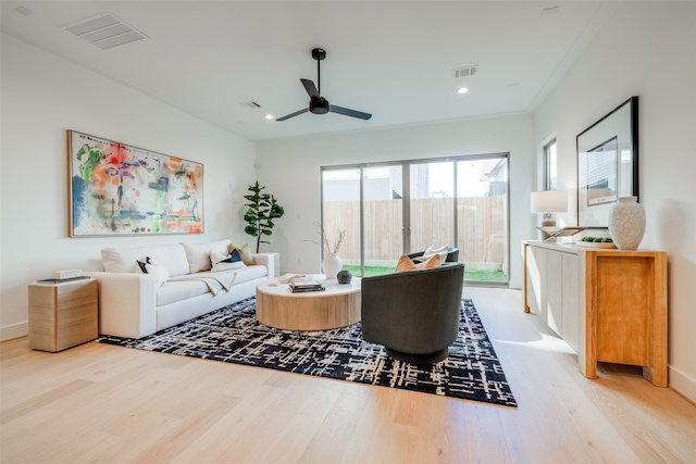 living room with ceiling fan, light wood-type flooring, and ornamental molding