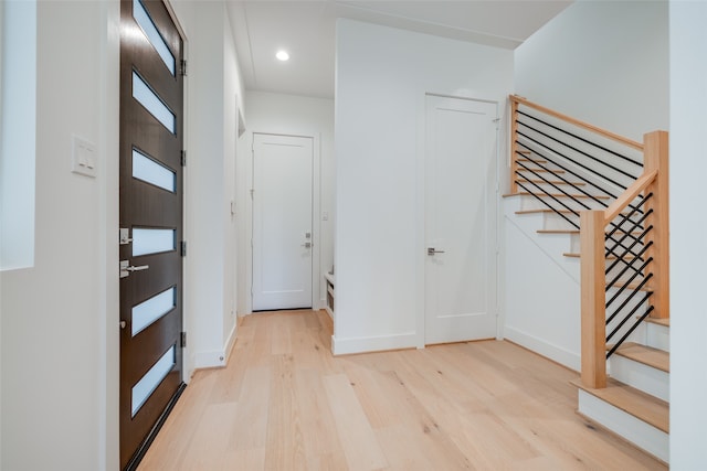 entryway with recessed lighting, light wood-style flooring, stairs, and baseboards