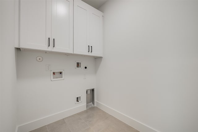 clothes washing area featuring electric dryer hookup, hookup for a gas dryer, cabinet space, baseboards, and hookup for a washing machine