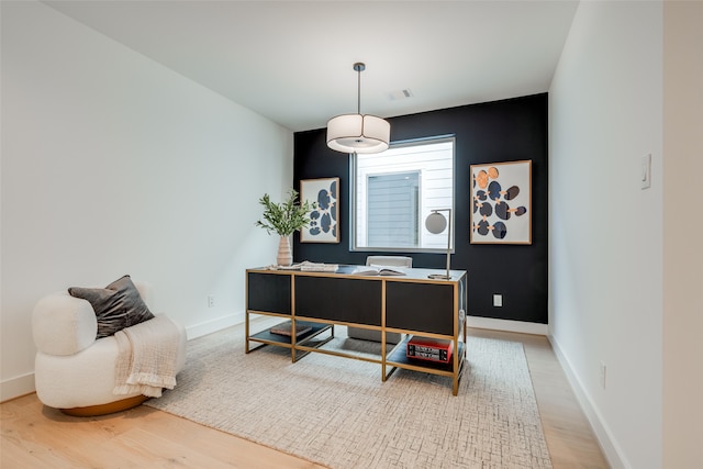 office space with wood finished floors, visible vents, and baseboards