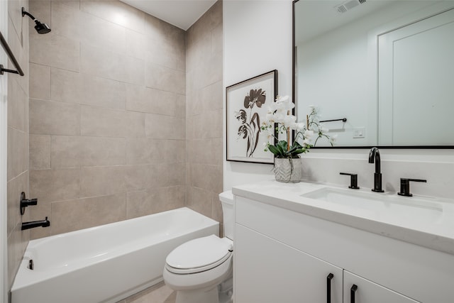 full bathroom featuring tiled shower / bath combo, toilet, and vanity