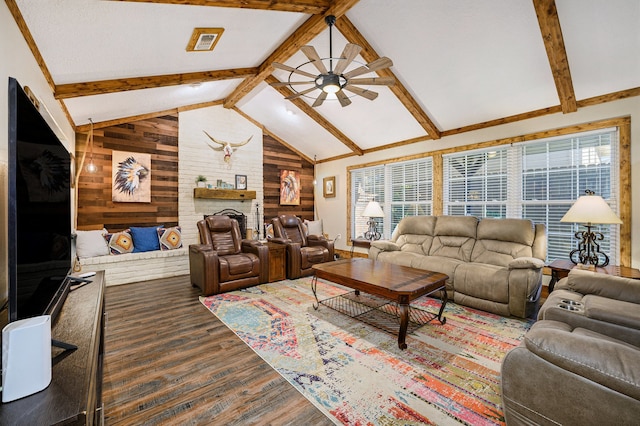 living room with dark hardwood / wood-style flooring, lofted ceiling with beams, plenty of natural light, and wooden walls