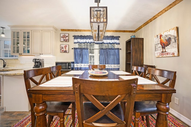 dining space with crown molding and dark wood-type flooring