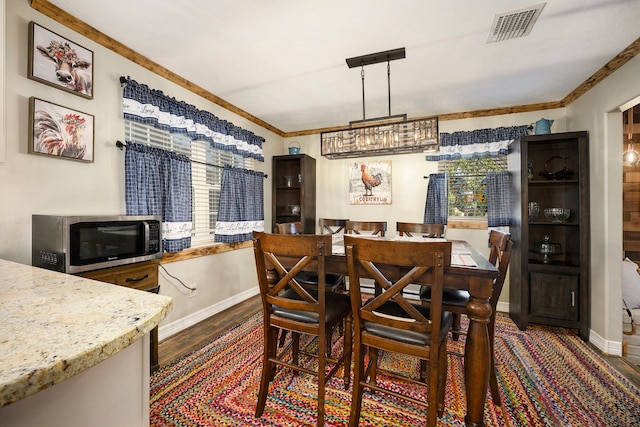 dining area with dark hardwood / wood-style flooring and ornamental molding