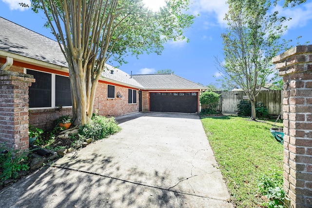 single story home featuring a garage and a front lawn