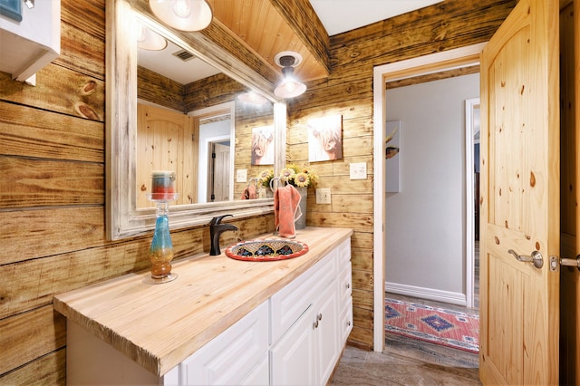 bathroom with vanity and wooden walls