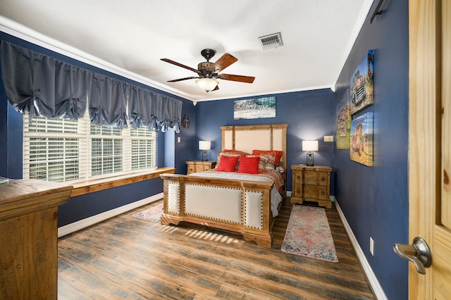 bedroom with dark hardwood / wood-style floors, ceiling fan, and crown molding