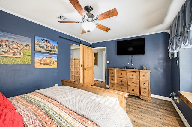 bedroom featuring a barn door, ceiling fan, dark hardwood / wood-style flooring, and crown molding