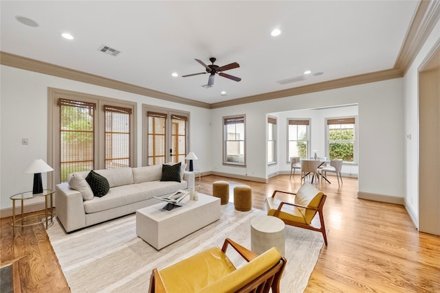 living room featuring ceiling fan, light hardwood / wood-style floors, and crown molding