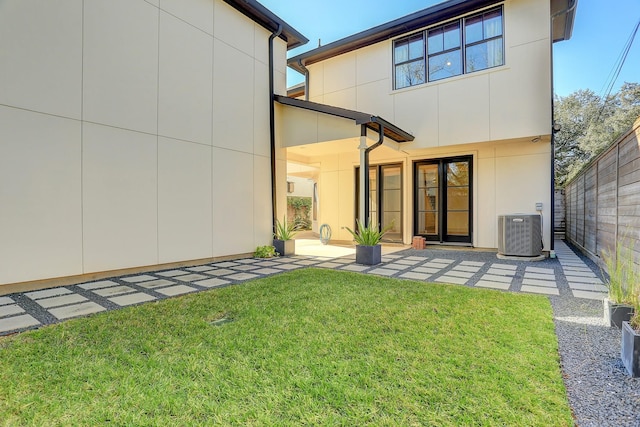 back of house with cooling unit and a yard