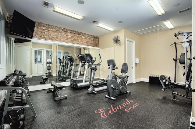 workout area featuring brick wall