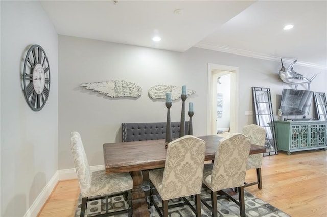 dining space featuring hardwood / wood-style flooring and ornamental molding