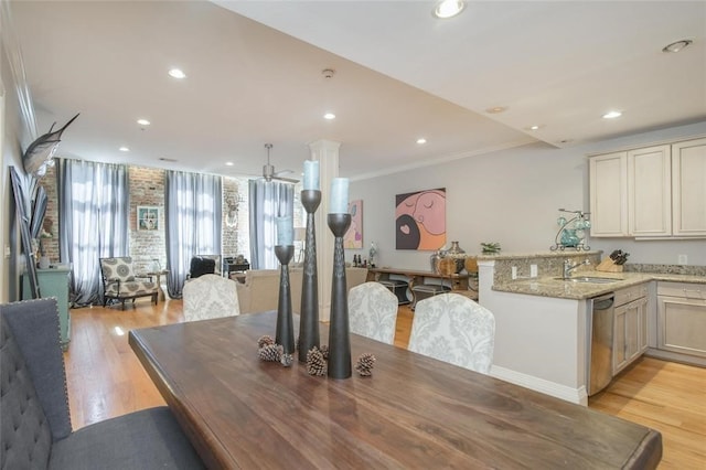 dining space with sink, light hardwood / wood-style flooring, ornamental molding, and ceiling fan