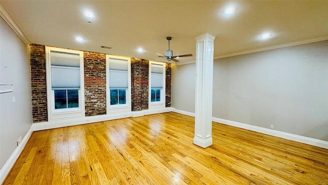 unfurnished living room with crown molding, brick wall, decorative columns, and light hardwood / wood-style flooring