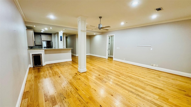 basement featuring stainless steel refrigerator with ice dispenser, ornamental molding, ceiling fan, and light wood-type flooring