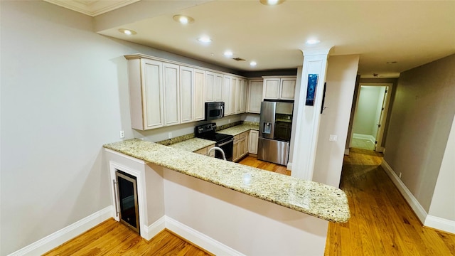 kitchen with light stone counters, appliances with stainless steel finishes, kitchen peninsula, light hardwood / wood-style floors, and white cabinets