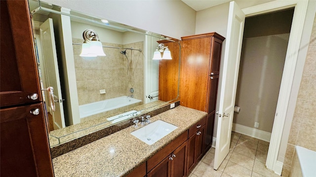 bathroom with tiled shower / bath combo, vanity, and tile patterned flooring