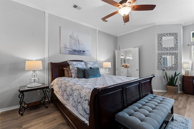 bedroom featuring connected bathroom, hardwood / wood-style flooring, ceiling fan, and crown molding