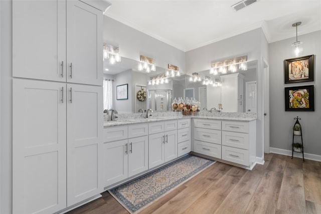 bathroom with hardwood / wood-style floors, vanity, and crown molding