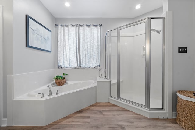 bathroom with hardwood / wood-style floors and independent shower and bath