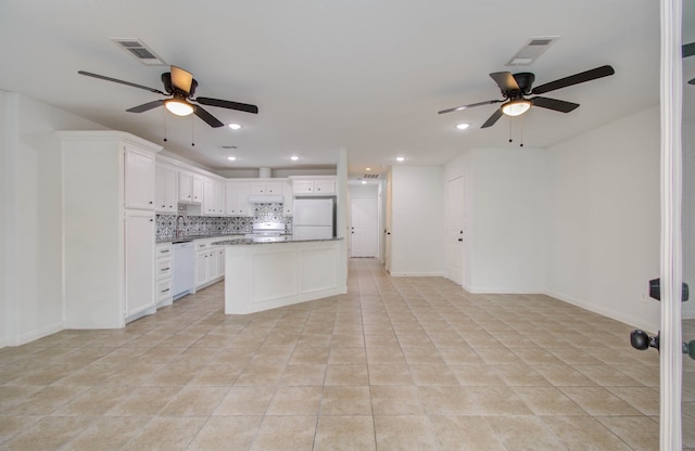 kitchen featuring a center island, light tile patterned flooring, backsplash, white appliances, and white cabinets