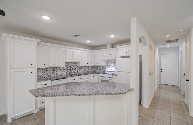 kitchen featuring white appliances, tasteful backsplash, white cabinetry, and sink