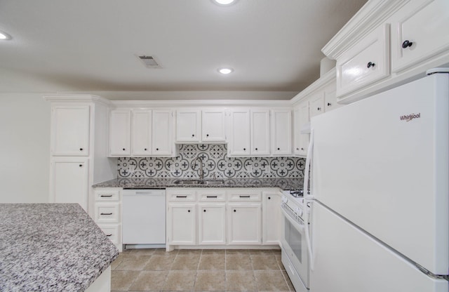 kitchen with backsplash, white appliances, sink, light tile patterned floors, and white cabinetry