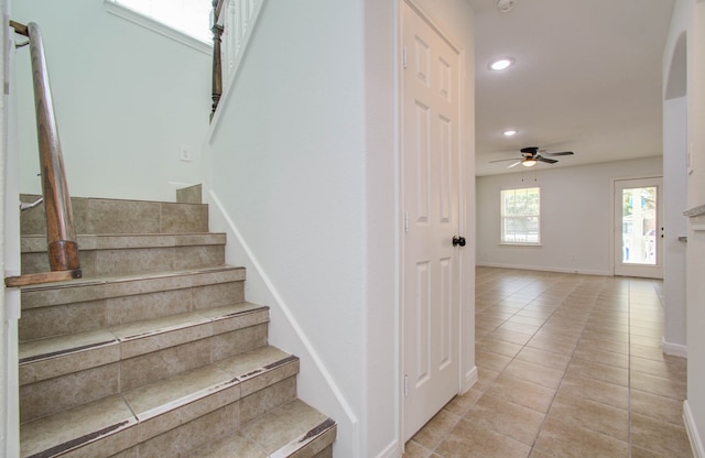 staircase featuring tile patterned floors and ceiling fan