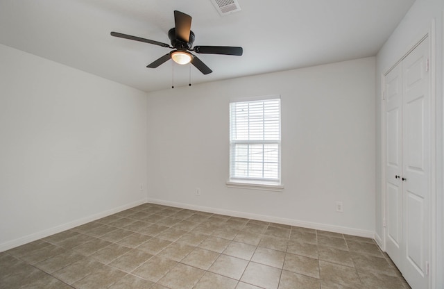 empty room with ceiling fan and light tile patterned flooring