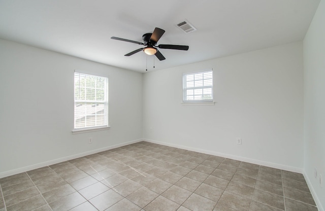 empty room with ceiling fan and light tile patterned floors