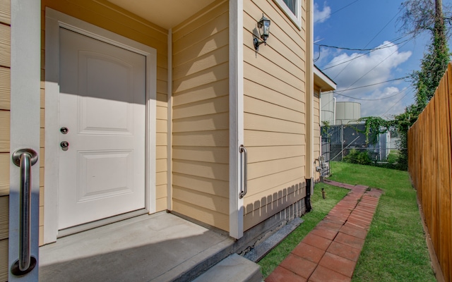 view of exterior entry featuring a yard