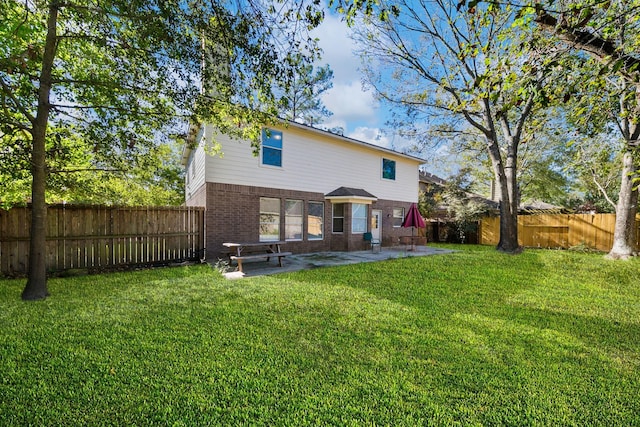 back of house with a yard and a patio