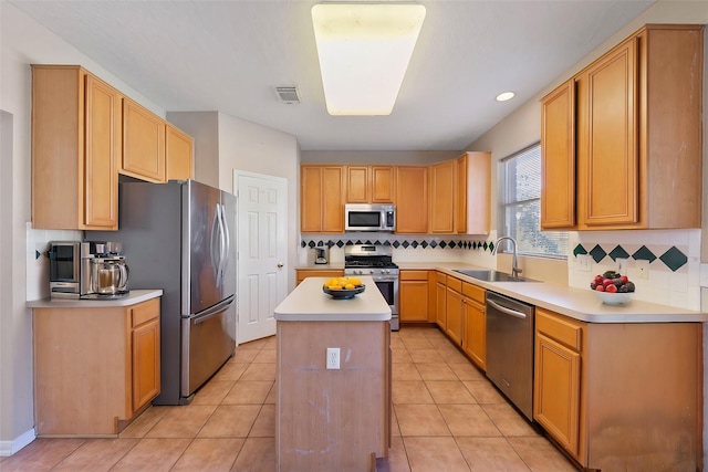 kitchen featuring sink, light tile patterned floors, stainless steel appliances, and a center island