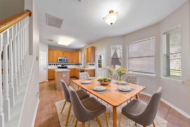 dining room with sink and light wood-type flooring