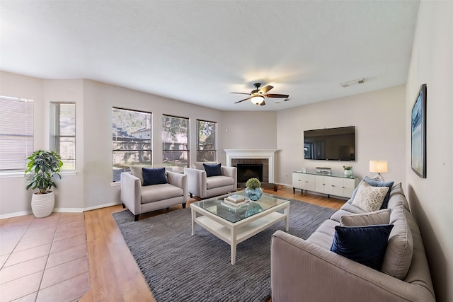 living room featuring hardwood / wood-style flooring, a fireplace, and ceiling fan