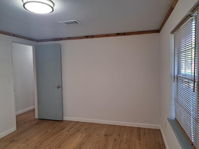 unfurnished room featuring a textured ceiling and light wood-type flooring