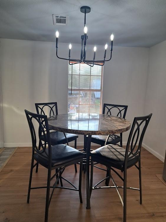 dining area featuring dark hardwood / wood-style floors and an inviting chandelier