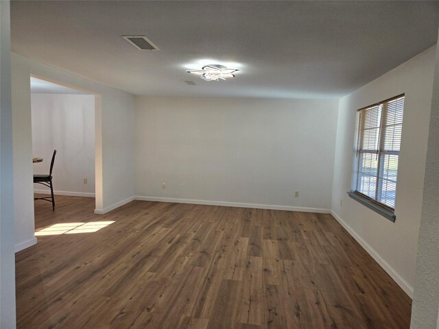 empty room with dark hardwood / wood-style flooring