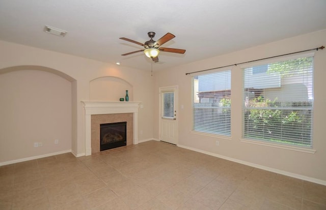 unfurnished living room featuring a tile fireplace, ceiling fan, and light tile patterned flooring