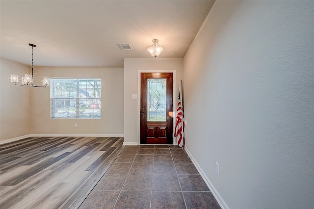 foyer entrance with a chandelier and dark hardwood / wood-style flooring