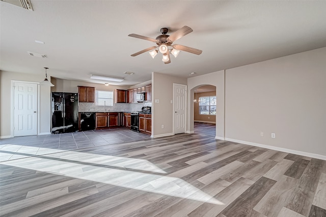 unfurnished living room with light hardwood / wood-style flooring, ceiling fan, and sink