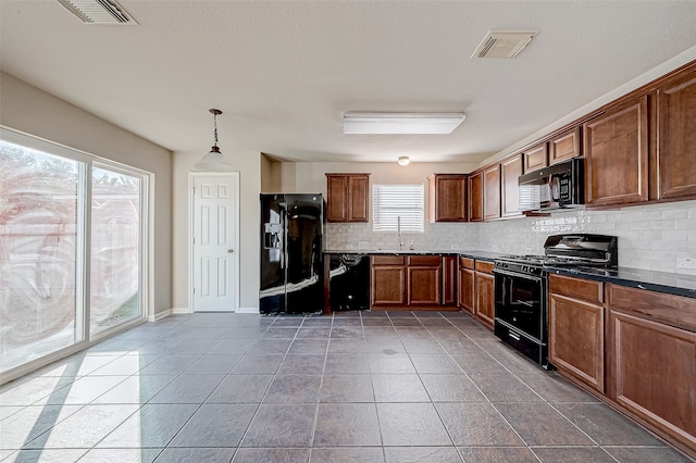 kitchen with sink, tile patterned floors, decorative light fixtures, decorative backsplash, and black appliances