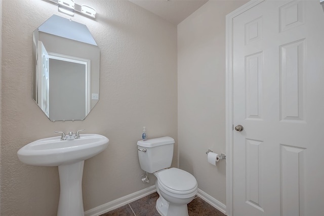 bathroom featuring tile patterned flooring, toilet, and sink