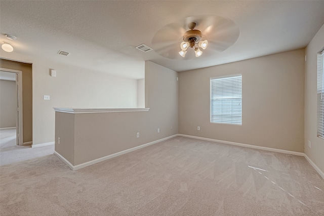 carpeted spare room with ceiling fan