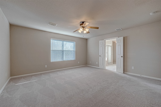 carpeted spare room featuring ceiling fan and a textured ceiling