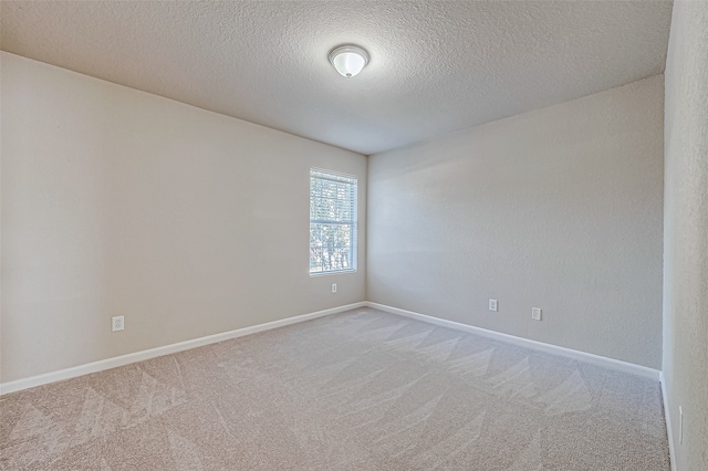 spare room featuring carpet flooring and a textured ceiling